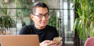 Image of senior Asian man using mobile phone