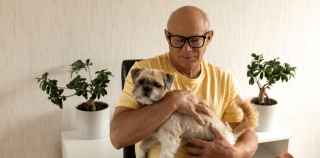 Image of senior man holding pet dog