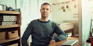 Image of a man sitting at his computer at home